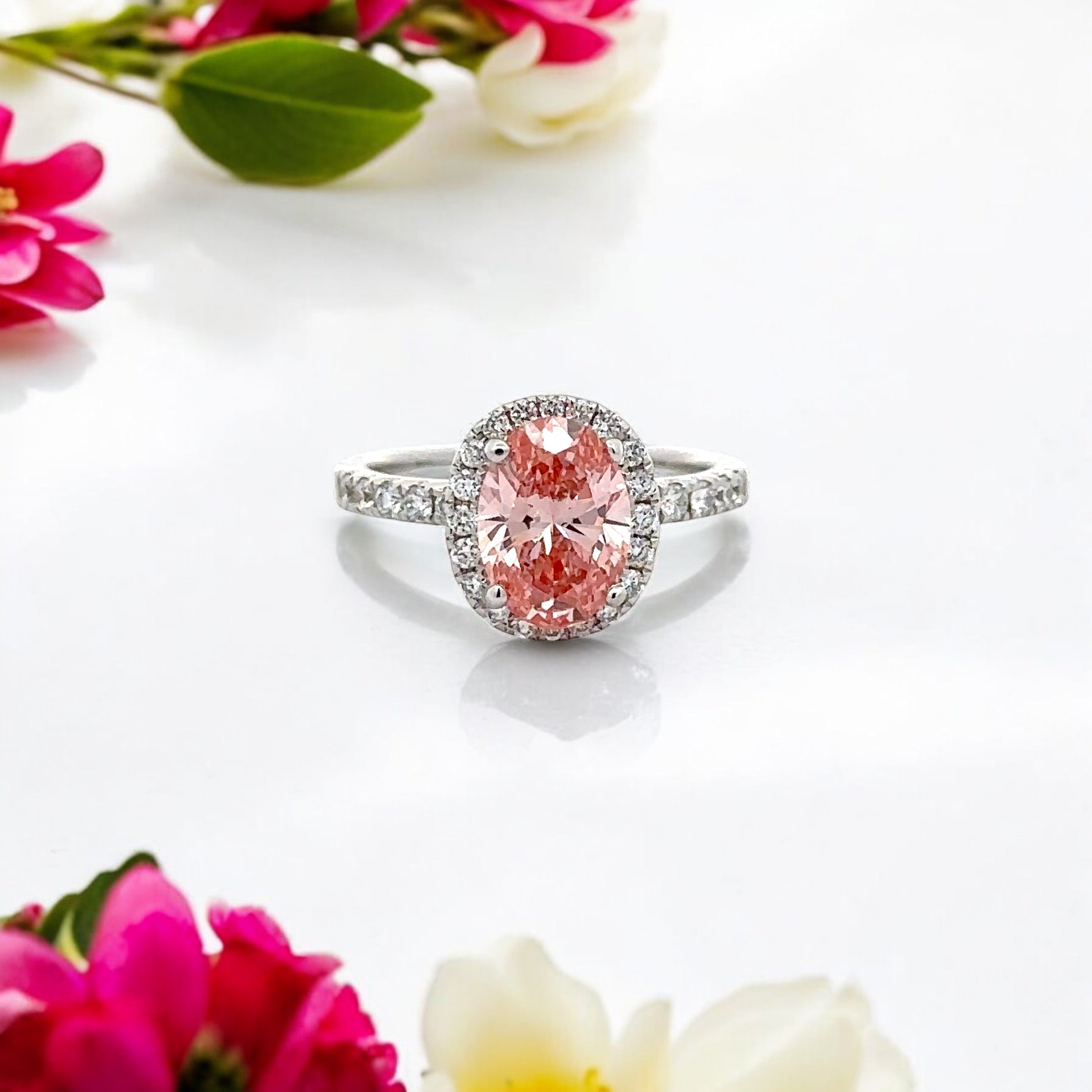 18K PINK DIAMOND OVAL CUT CENTRE STONE IN A HALO SETTING IN A 18K DIAMOND ACCENTED BAND – 2.55 CTW