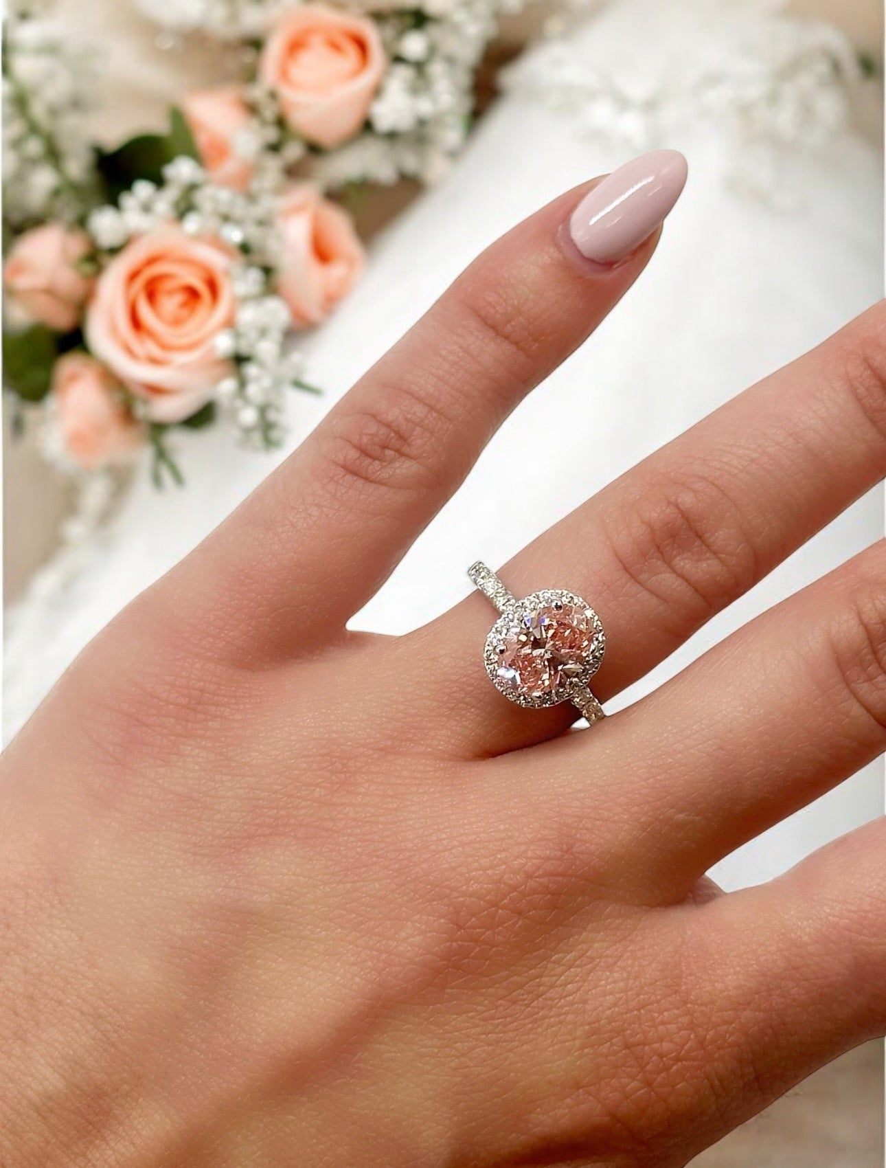 18K PINK DIAMOND OVAL CUT CENTRE STONE IN A HALO SETTING IN A 18K DIAMOND ACCENTED BAND – 2.55 CTW